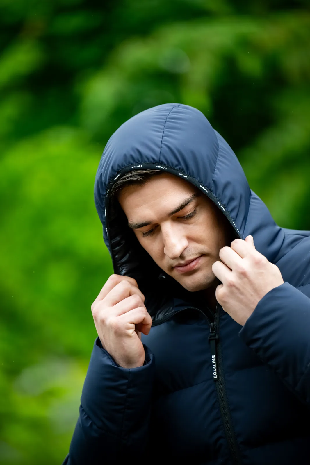 Man wearing the hood of the navy Equiline EQCAN puffer jacket.